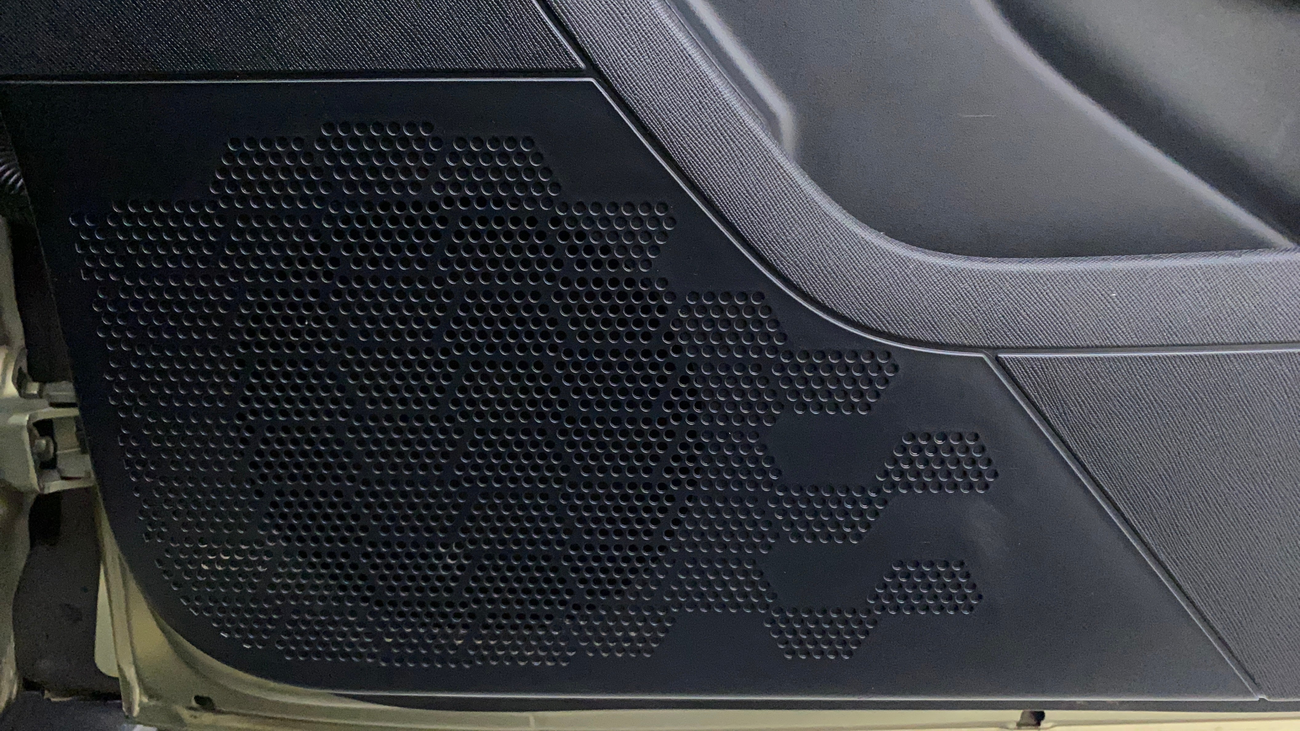 Close-up of a speaker grille on a Tata Nexon 2017-2023 door panel