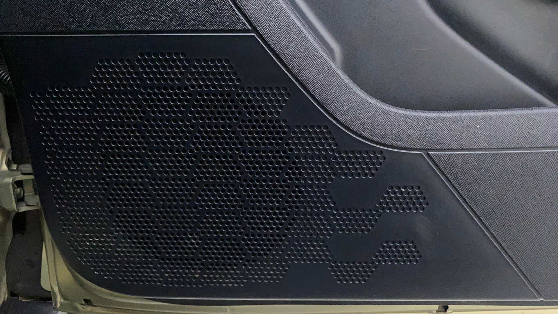 Close-up of a speaker grille on a Tata Nexon 2017-2023 door panel