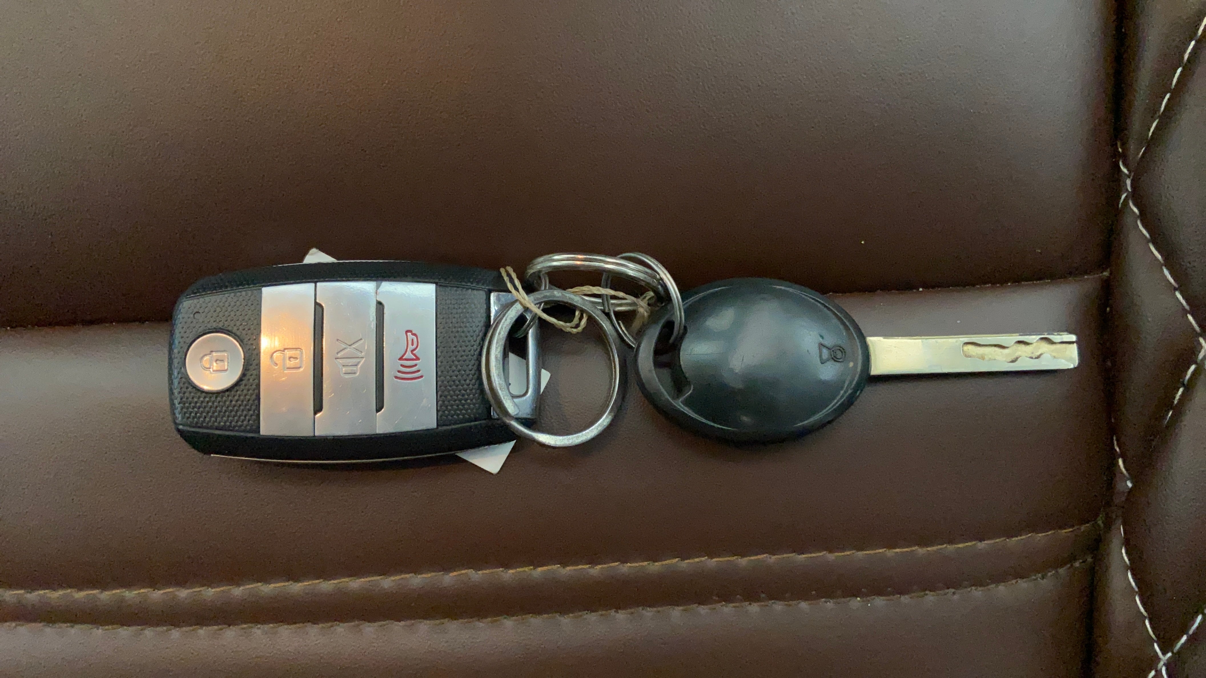Car key fob and key on brown leather seat of a Tata Punch