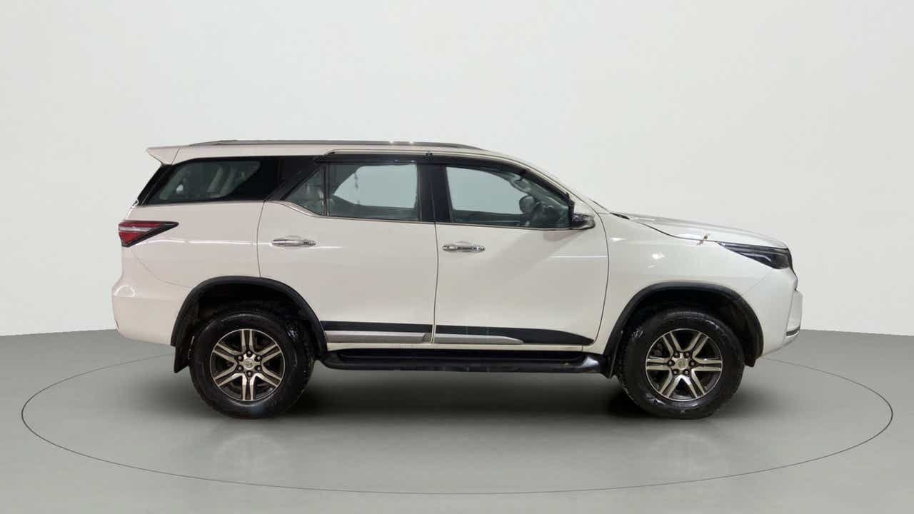 Side view of a platinum white pearl Toyota Fortuner