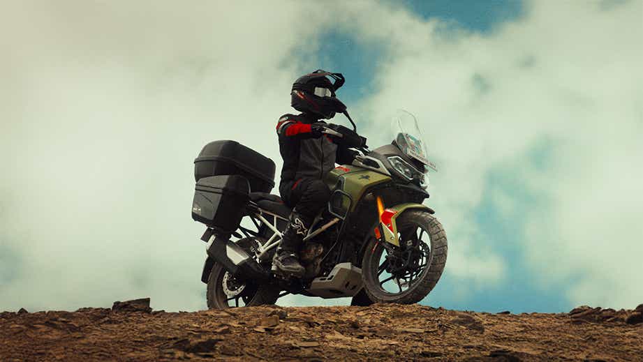 Side view of a Tarn Bronze TVS Apache RTX on a rocky trail