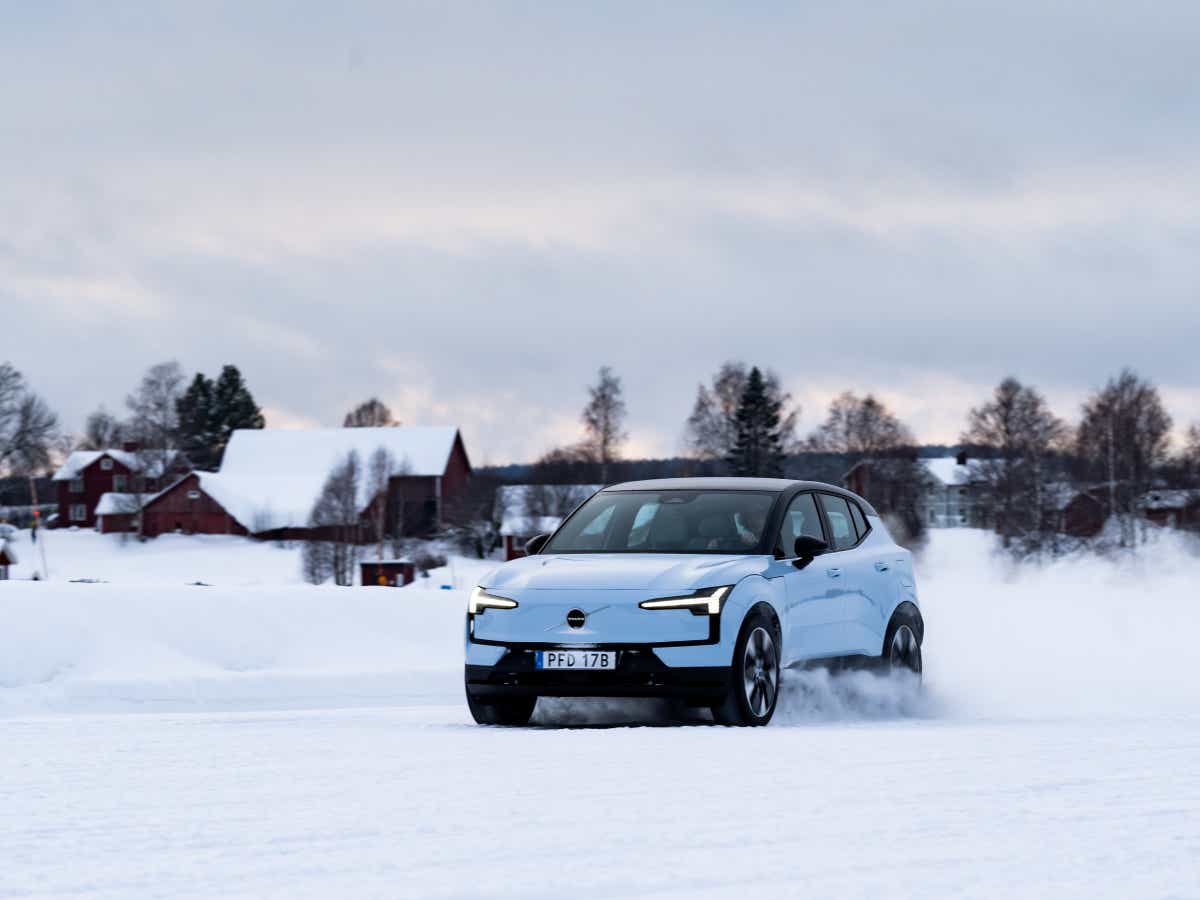 Front three-quarter of a cold blue Volvo EX30 driving on snow