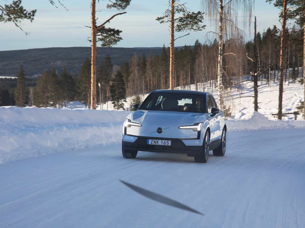 Front view of a crystal white Volvo EX30 on a snowy road